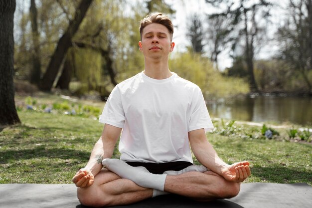 Hombre de tiro completo meditando al aire libre