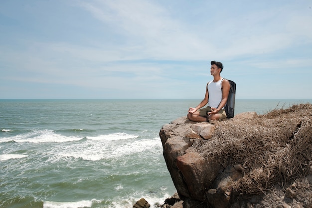 Hombre de tiro completo meditando en la naturaleza