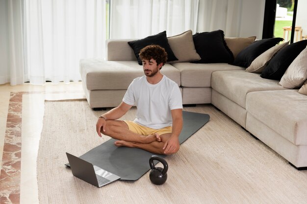 Hombre de tiro completo meditando sobre estera