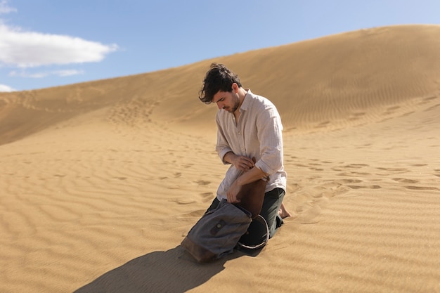 Hombre de tiro completo con mochila en el desierto.