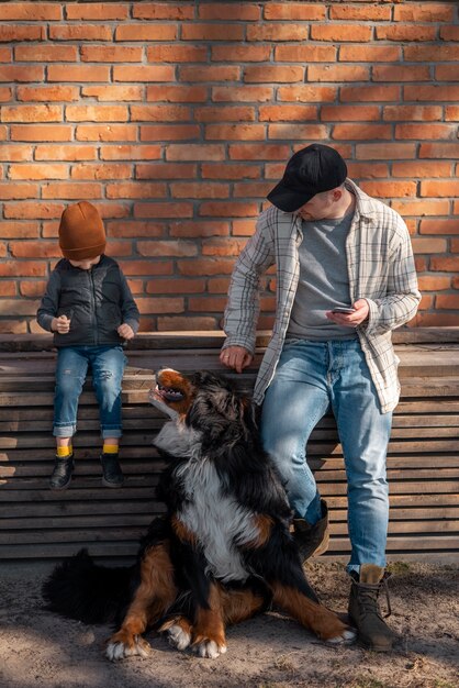 Hombre de tiro completo, niño y perro al aire libre.