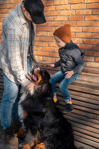 Hombre de tiro completo, niño y perro en la vida rural.