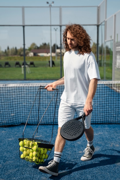 Hombre de tiro completo con paleta de tenis