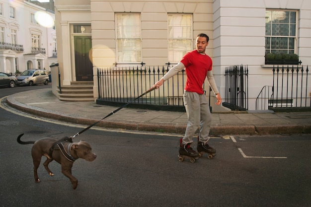 Foto gratuita hombre de tiro completo con patineta y perro.