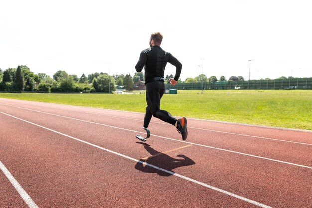 Hombre de tiro completo con prótesis en pista de atletismo