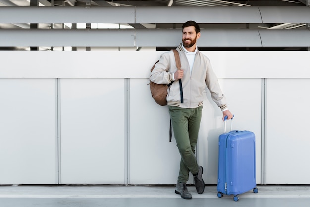 Hombre de tiro completo que viaja con equipaje