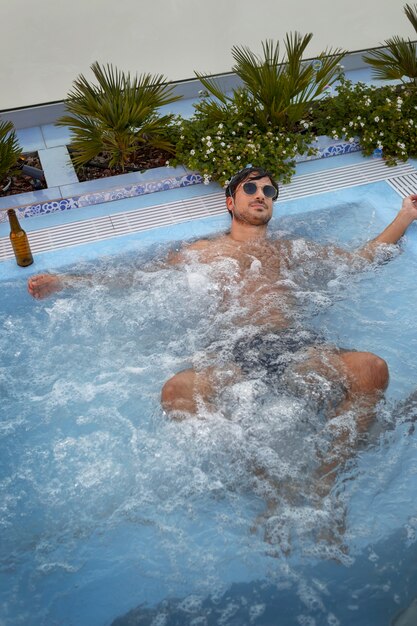 Hombre de tiro completo relajándose en el jacuzzi