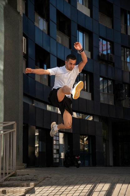 Hombre de tiro completo saltando al aire libre