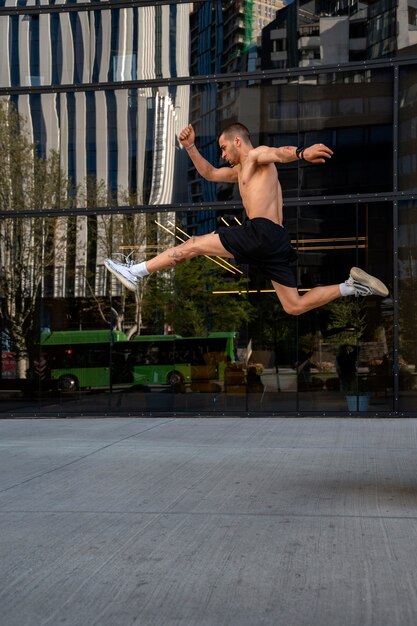 Hombre de tiro completo saltando al aire libre