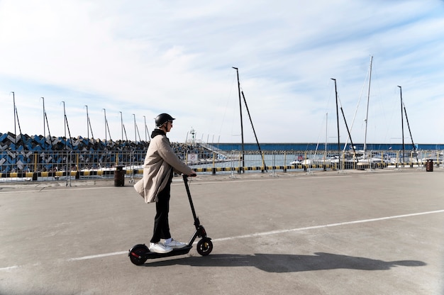 Foto gratuita hombre de tiro completo en scooter eléctrico al aire libre