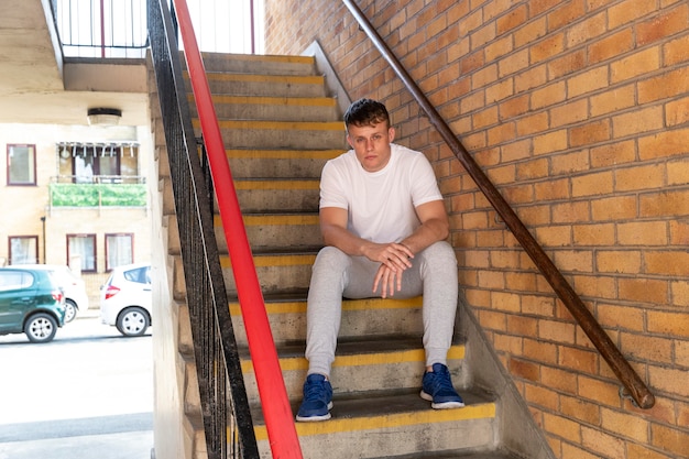 Hombre de tiro completo sentado en las escaleras