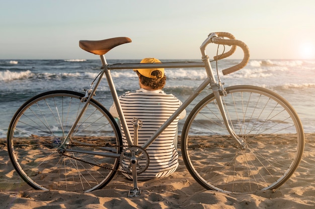 Foto gratuita hombre de tiro completo sentado en la playa