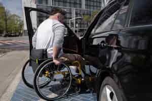 Foto gratuita hombre de tiro completo en silla de ruedas cerca del coche