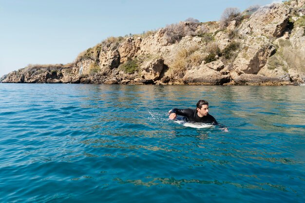 Hombre de tiro completo con tabla de surf