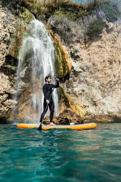 Hombre de tiro completo en tabla de surf