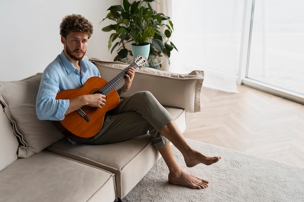 Foto gratuita hombre de tiro completo tocando la guitarra