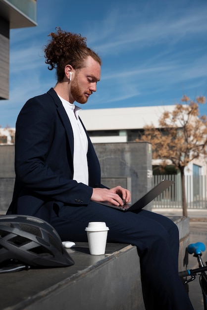 Foto gratuita hombre de tiro completo trabajando en la computadora portátil al aire libre