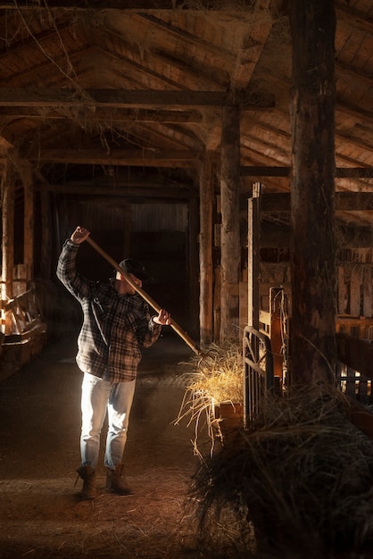 Hombre de tiro completo trabajando en la vida rural del granero