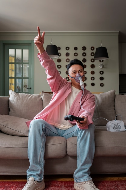 Foto gratuita hombre de tiro completo usando nebulizador en casa