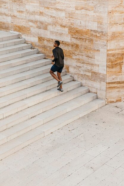 Hombre de tiro largo corriendo en las escaleras