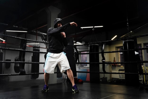 Hombre de tiro largo en entrenamiento de ropa deportiva en ring de boxeo