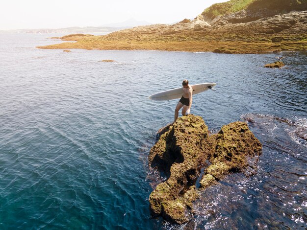 Hombre de tiro largo preparándose para surfear