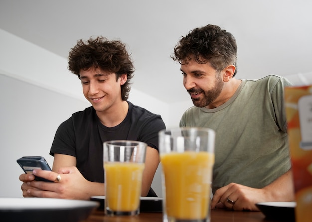 Foto gratuita hombre de tiro medio y adolescente con jugo.