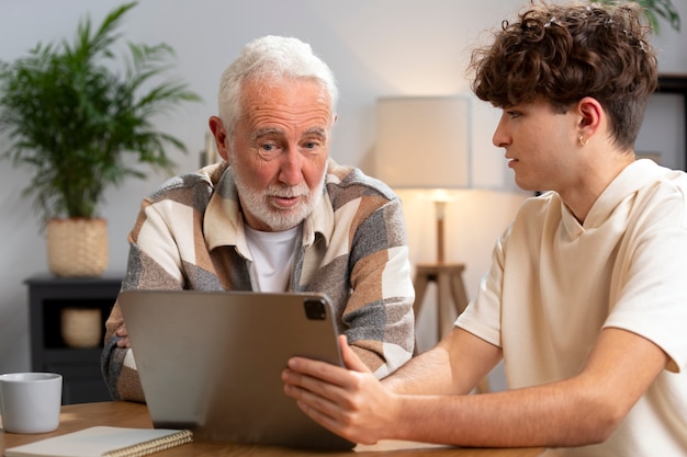 Hombre de tiro medio y adolescente mirando la tableta