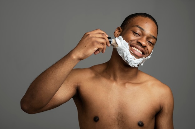 Hombre de tiro medio aplicando crema de afeitar