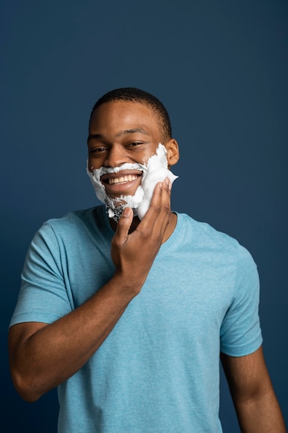 Hombre de tiro medio aplicando crema de afeitar