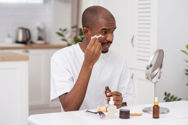 Hombre de tiro medio aplicando tratamiento facial