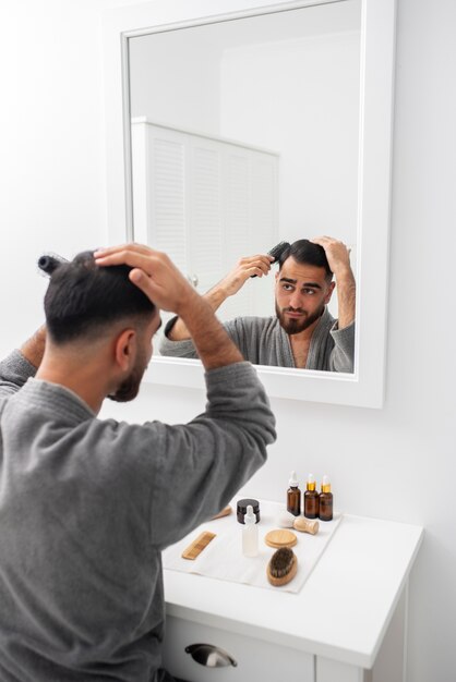 Hombre de tiro medio arreglando el cabello