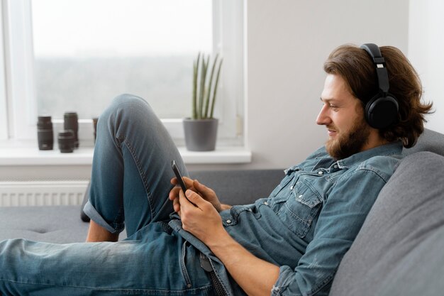 Foto gratuita hombre de tiro medio con auriculares en el sofá