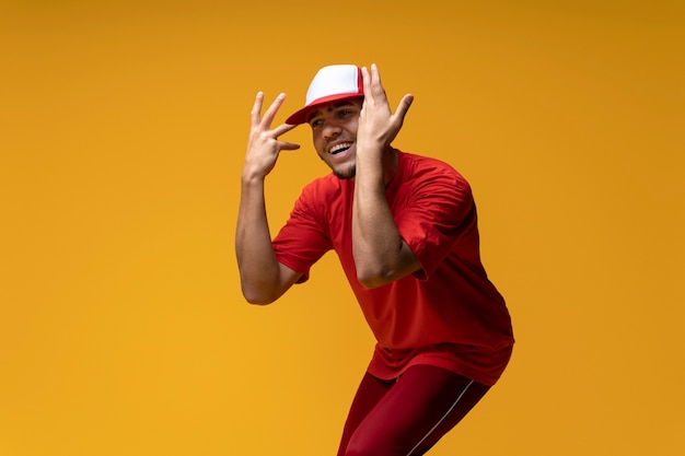 Hombre de tiro medio bailando con fondo amarillo.