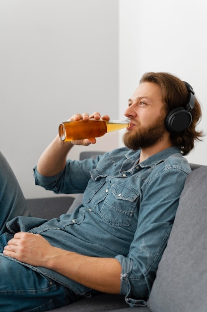 Foto gratuita hombre de tiro medio con bebida en casa