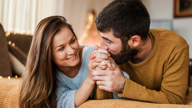 Hombre de tiro medio besando la mano de la mujer