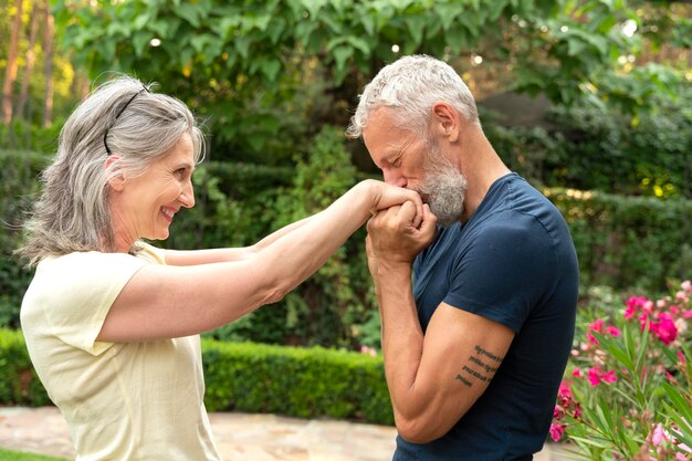 Hombre de tiro medio besando las manos de la mujer