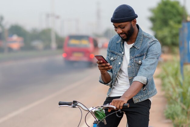 Hombre de tiro medio con bicicleta y teléfono