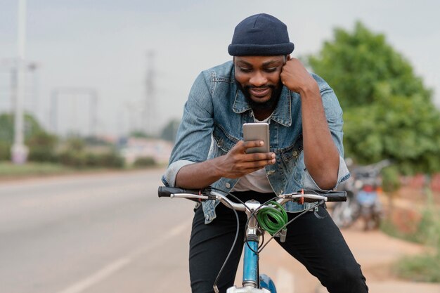 Hombre de tiro medio en bicicleta con teléfono