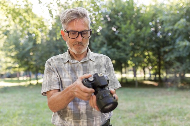 Hombre de tiro medio con cámara de fotos