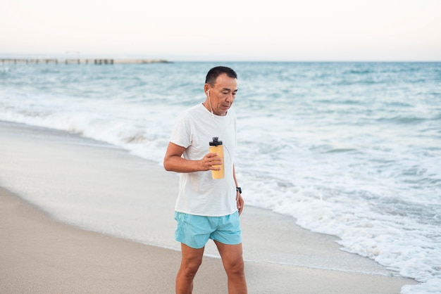 Hombre de tiro medio caminando en la playa