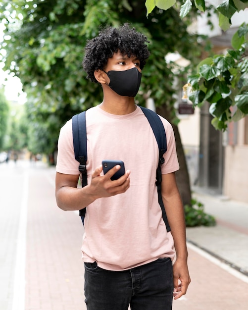 Hombre de tiro medio caminando con teléfono