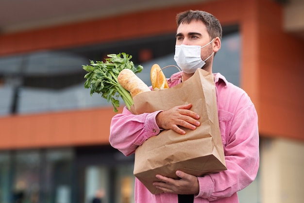 Hombre de tiro medio cargando comestibles