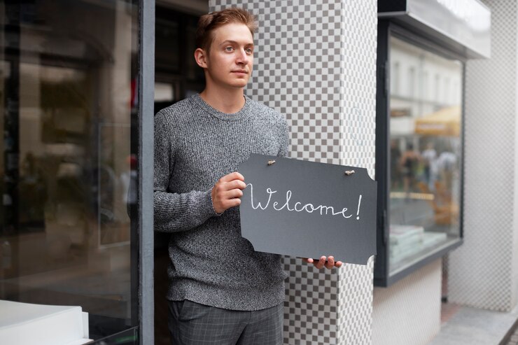 Foto gratuito hombre de tiro medio con cartel de bienvenida