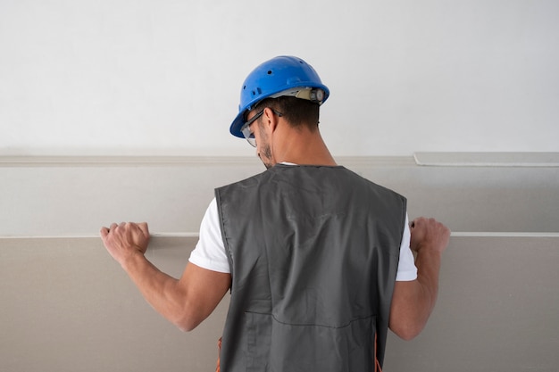 Hombre de tiro medio con casco en el trabajo