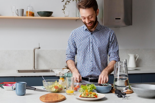 Hombre de tiro medio cocinando en la cocina