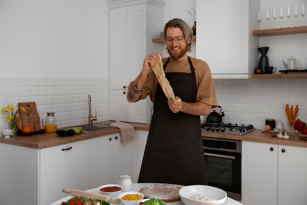 Foto gratuita hombre de tiro medio cocinando pizza