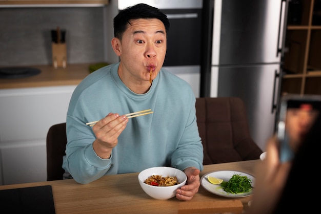 Foto gratuita hombre de tiro medio comiendo comida asiática