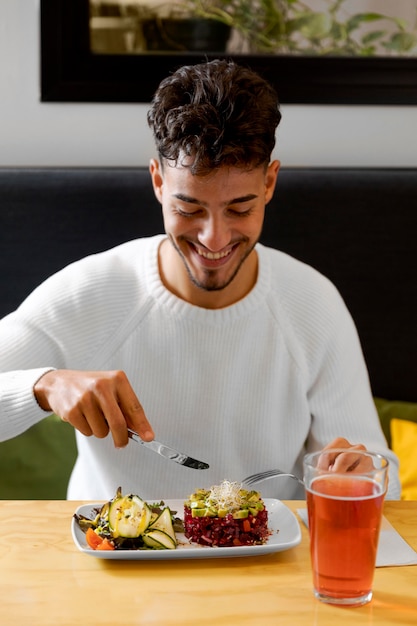 Hombre de tiro medio comiendo comida vegetariana