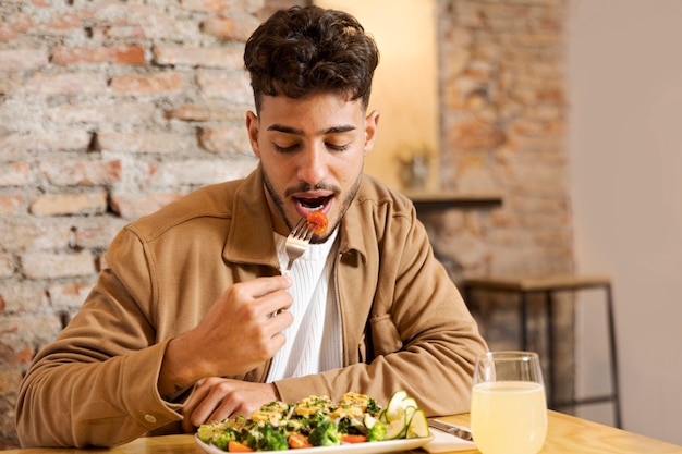 Hombre de tiro medio comiendo en interiores